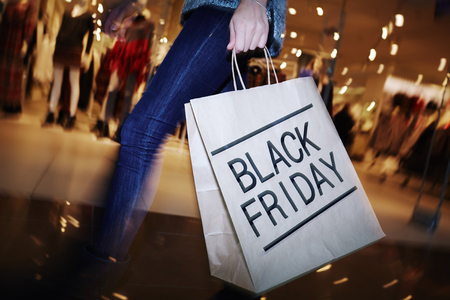 47782301 - modern shopper with black friday paperbag going in the mall